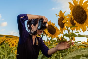 a person standing in front of a sunflower